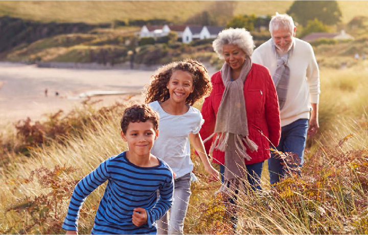 A family taking a walk together on a sunny hillside as a Stress Care activity.